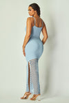 Woman wearing a light blue dress with a mesh crochet at the bottom of dress
 on a plain background